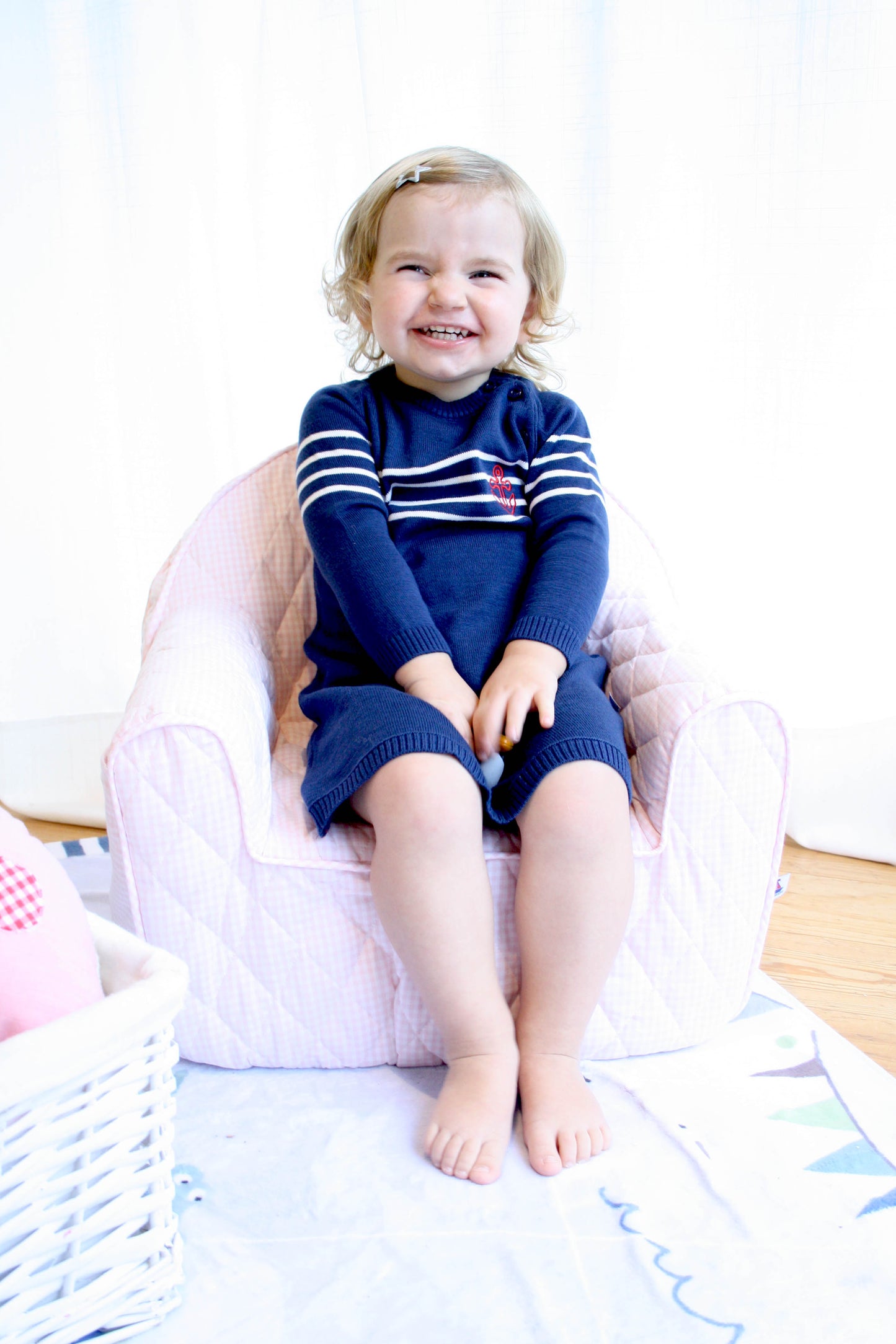 Maedchen-mit-Strickkleid-lachend-im-Sessel-lowJqyWOw4sLUoLr